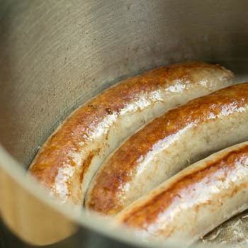Browned sausage in a pan.