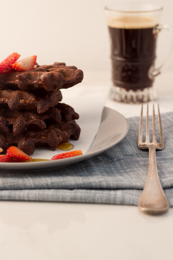 Brownie waffles on a plate garnished with strawberries. 
