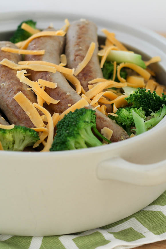 Broccoli, cheese, sausage, and quinoa served in a white heatproof dish.