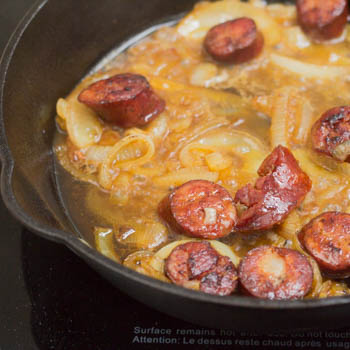 Onions and chorizo in pan, onions are softened.