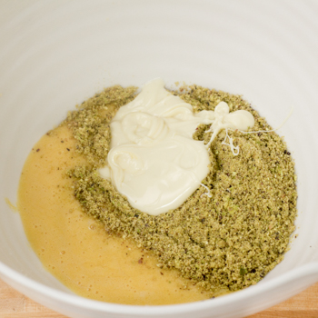 White chocolate, ground pistachios and egg mixed in a bowl.