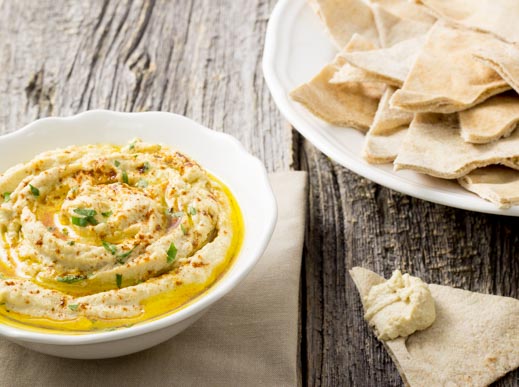 hummus in a bowl served with pita 