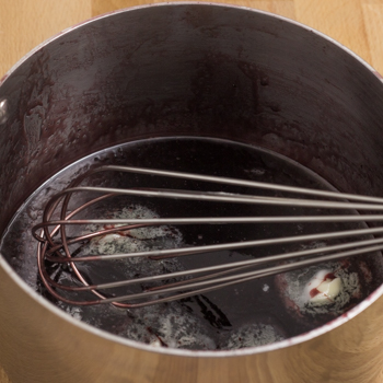 Wine being whisked into a sauce.